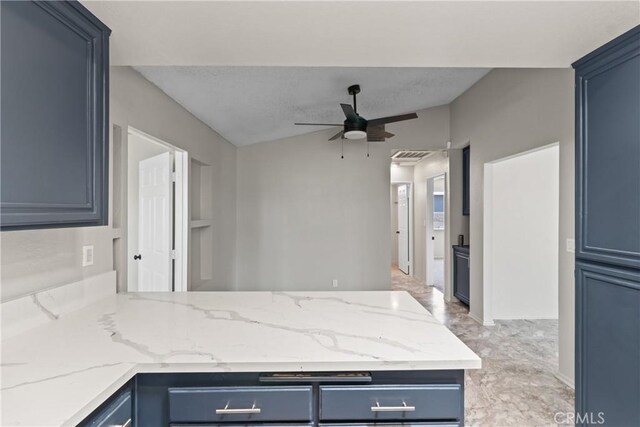 kitchen featuring ceiling fan, light stone countertops, blue cabinetry, a peninsula, and visible vents