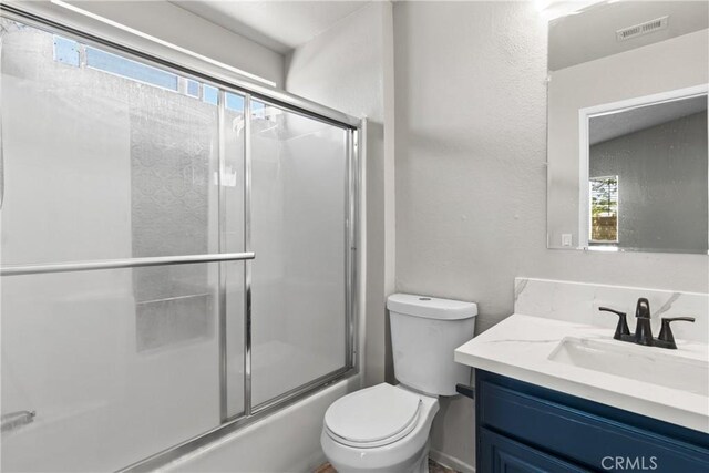 bathroom featuring visible vents, a healthy amount of sunlight, toilet, and vanity