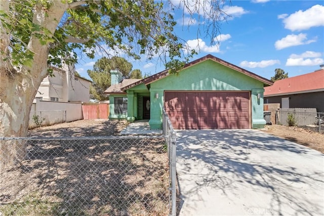 single story home with concrete driveway, stucco siding, fence private yard, and a garage