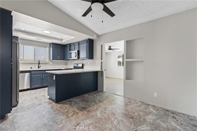 kitchen featuring a sink, ceiling fan, stainless steel appliances, and a textured ceiling