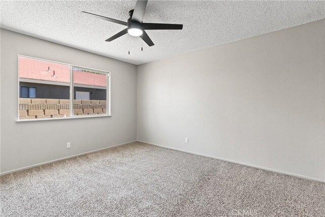 spare room featuring carpet floors, a ceiling fan, a textured ceiling, and baseboards