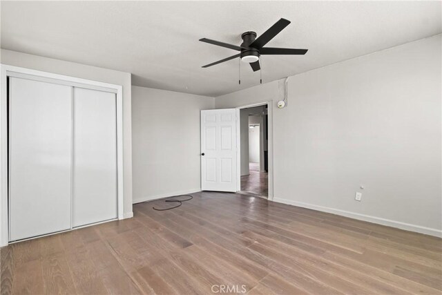 unfurnished bedroom with baseboards, a closet, and wood finished floors
