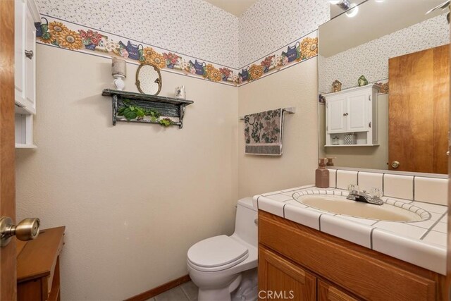 36556 Mudge Ranch Rd, Coarsegold, CA 93614 - half bathroom featuring toilet, tile patterned floors, wallpapered walls, and vanity