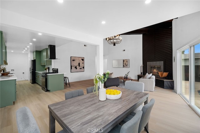 6316 Michelson St, Lakewood, CA 90713 - dining space featuring light wood-type flooring, recessed lighting, a large fireplace, and an inviting chandelier