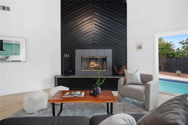 6316 Michelson St, Lakewood, CA 90713 - living area featuring a towering ceiling, a large fireplace, wood finished floors, and visible vents