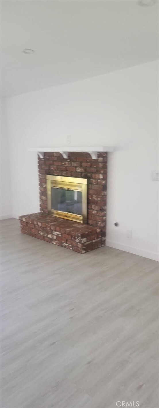 16737 E Greenhaven St, Covina, CA 91722 - detailed view of a brick fireplace and wood finished floors