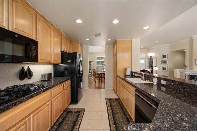 kitchen featuring decorative backsplash, recessed lighting, a sink, light tile patterned floors, and black appliances