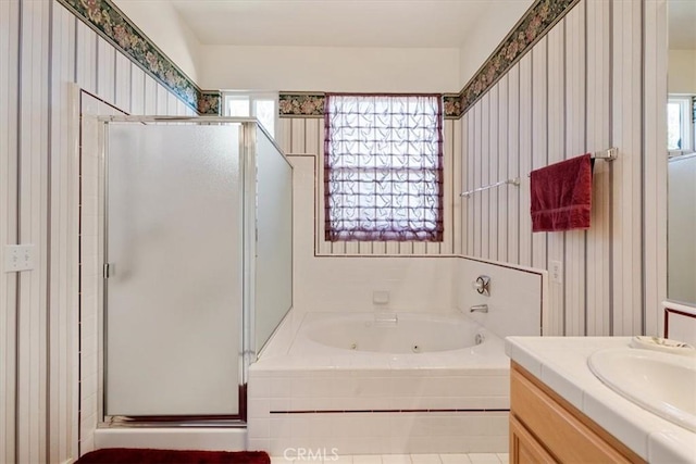 full bathroom featuring a whirlpool tub, vanity, a stall shower, and wallpapered walls