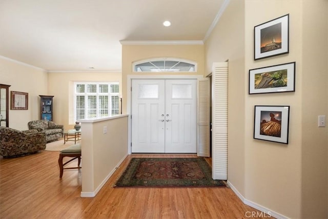entryway with baseboards, ornamental molding, and wood finished floors