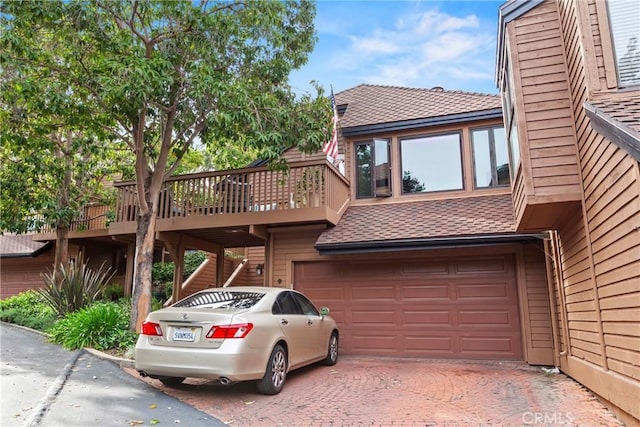 672 Serrano Dr Unit 9, San Luis Obispo, CA 93405 - view of home's exterior featuring an attached garage, a shingled roof, and decorative driveway