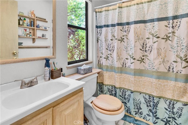 bathroom with toilet, a shower with shower curtain, and vanity
