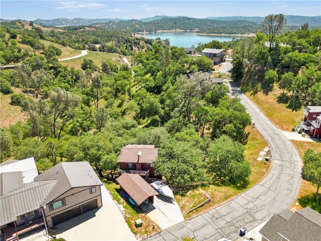 birds eye view of property featuring a wooded view and a water and mountain view