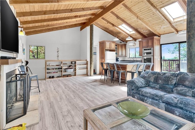 living area featuring a skylight, wood ceiling, and light wood-style flooring