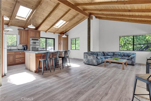 2664 Pine Ridge Rd, Bradley, CA 93426 - living room featuring a skylight, wood ceiling with exposed beams, light wood finished floors, and high vaulted ceiling