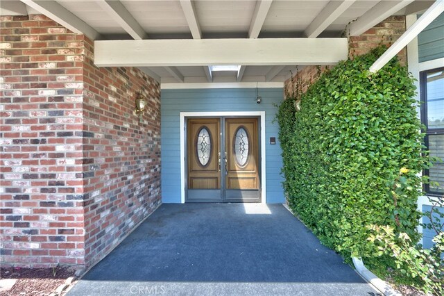 view of exterior entry with brick siding
