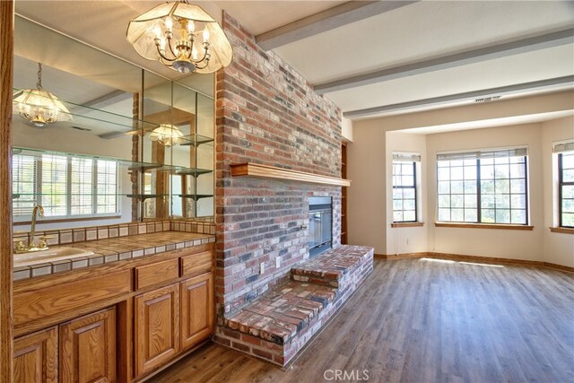 interior space with a sink, baseboards, wood finished floors, and a notable chandelier
