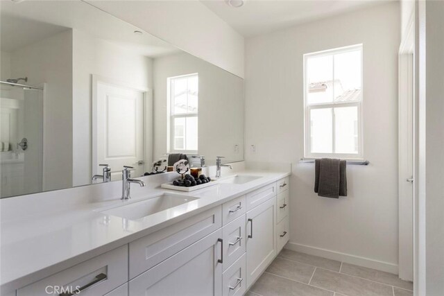 bathroom featuring a sink, a healthy amount of sunlight, and a shower stall