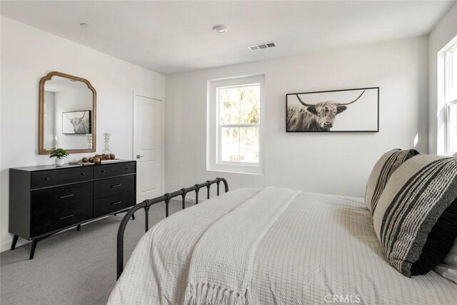 carpeted bedroom featuring visible vents