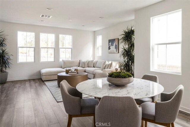 dining room with visible vents, baseboards, and light wood finished floors