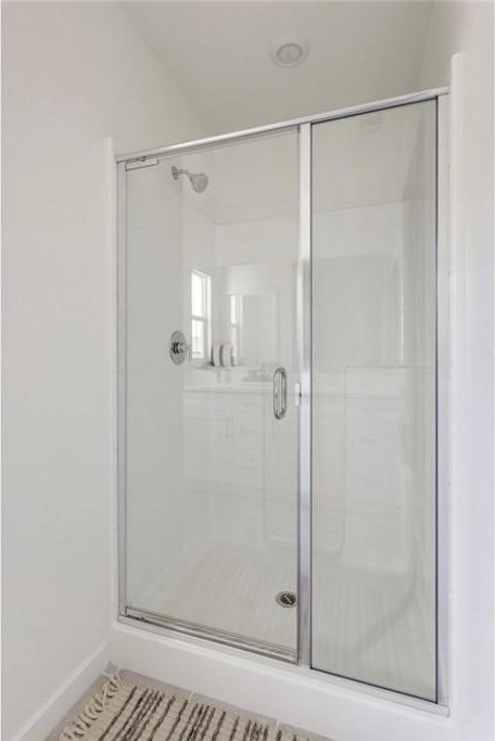 full bathroom with baseboards and a stall shower