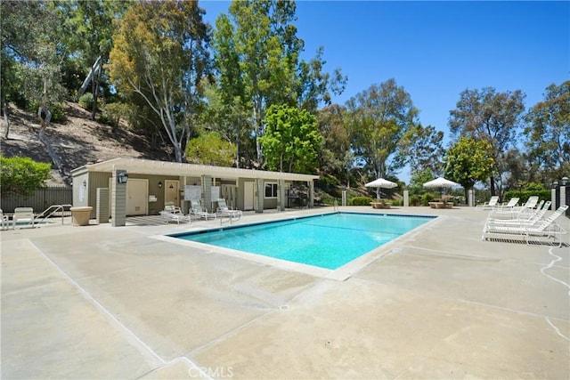 community pool with fence and a patio area
