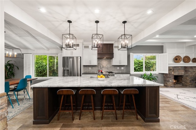 324 W S Ave, Redlands, CA 92373 - kitchen with stainless steel fridge, beamed ceiling, a chandelier, tasteful backsplash, and a large island with sink