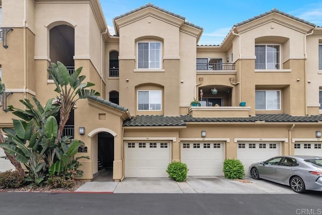10832 Scripps Ranch Blvd Unit 307, San Diego, CA 92131 - view of property with a garage, stucco siding, driveway, and a tiled roof