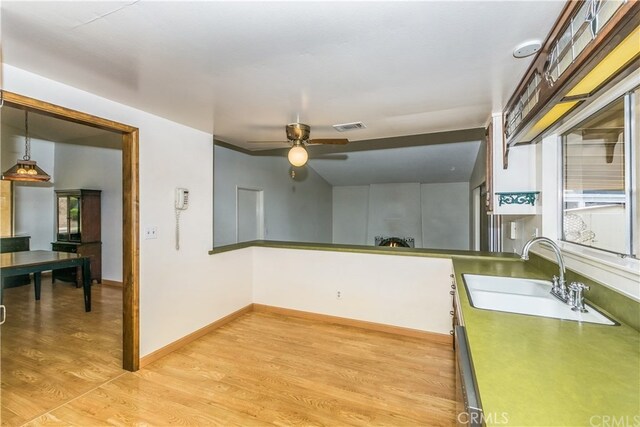 3899 28th St, Highland, CA 92346 - kitchen with a sink, a ceiling fan, light wood-style flooring, baseboards, and decorative light fixtures