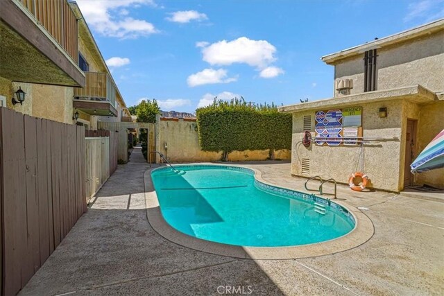 view of swimming pool featuring a fenced in pool, a fenced backyard, and a patio area