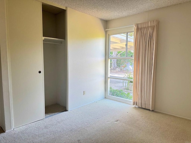 unfurnished bedroom with a closet, carpet flooring, and a textured ceiling