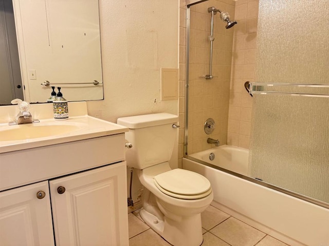 bathroom with vanity, bath / shower combo with glass door, tile patterned floors, and toilet