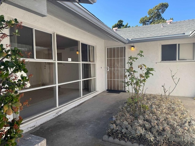 doorway to property featuring stucco siding