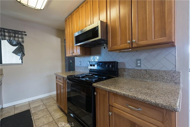 538 Milky Way, Vandenberg Village, CA 93436 - kitchen with brown cabinetry, baseboards, stainless steel microwave, black range with electric stovetop, and backsplash