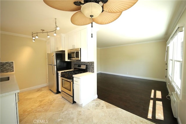 4325 Clinton St, Los Angeles, CA 90004 - kitchen with crown molding, white cabinetry, and appliances with stainless steel finishes