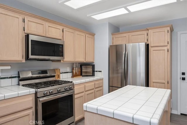 317 Alder St, Arroyo Grande, CA 93420 - kitchen featuring a center island, tile countertops, light brown cabinets, and stainless steel appliances