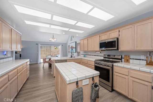 317 Alder St, Arroyo Grande, CA 93420 - kitchen featuring appliances with stainless steel finishes, vaulted ceiling, a peninsula, a chandelier, and light brown cabinets