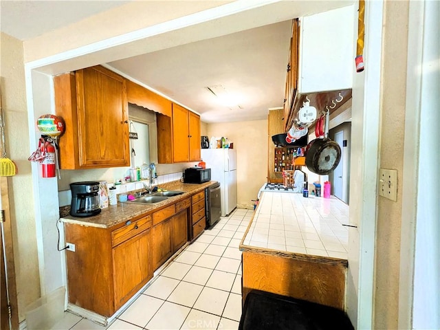 14136 Osage Rd, Apple Valley, CA 92307 - kitchen featuring a sink, brown cabinetry, dishwasher, black microwave, and light tile patterned floors