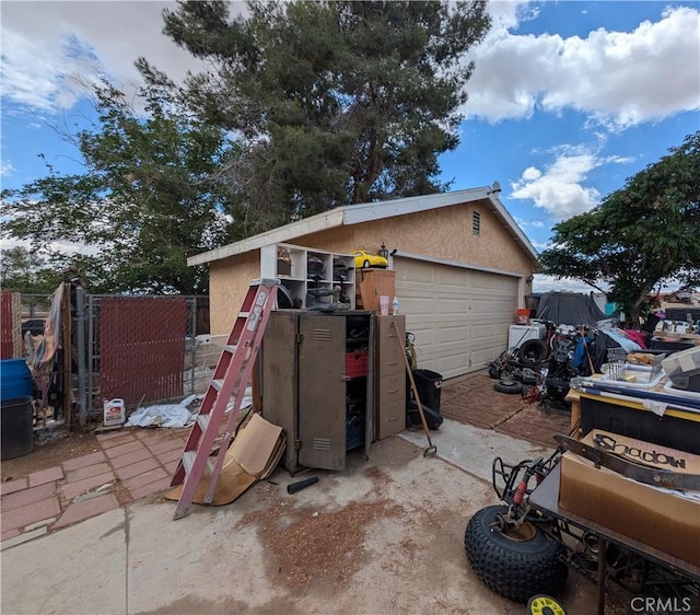 14136 Osage Rd, Apple Valley, CA 92307 - view of front of home with stucco siding, fence, a garage, and an outbuilding