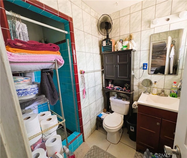14136 Osage Rd, Apple Valley, CA 92307 - bathroom featuring toilet, a stall shower, tile walls, tile patterned flooring, and vanity