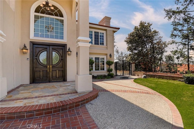 20454 Sartell Dr, Walnut, CA 91789 - view of exterior entry with a lawn, a gate, stucco siding, and a chimney
