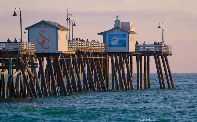 view of property's community featuring a pier and a water view