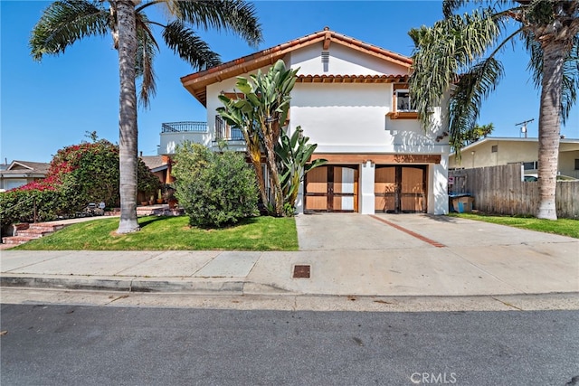view of front of property featuring a tiled roof, driveway, a garage, fence, and stucco siding