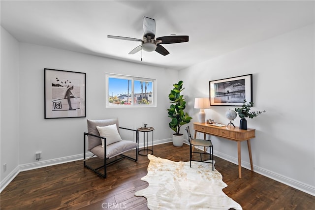 living area featuring baseboards, ceiling fan, and wood finished floors