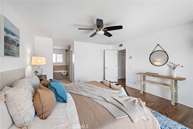 bedroom with baseboards, connected bathroom, wood finished floors, and visible vents