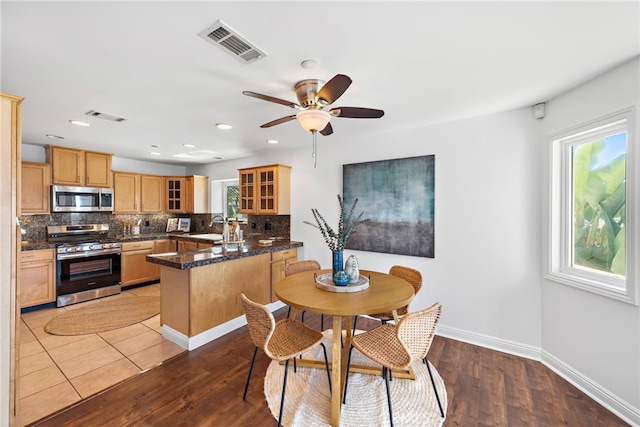 dining space with baseboards, a ceiling fan, wood finished floors, and visible vents