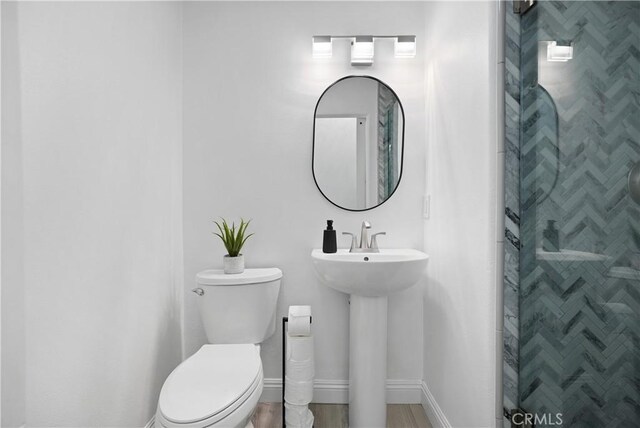 bathroom featuring baseboards, a stall shower, and toilet