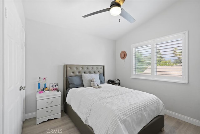 bedroom featuring a ceiling fan, baseboards, vaulted ceiling, and light wood-type flooring