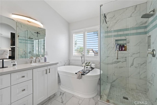 full bathroom featuring vanity, marble finish floor, a freestanding bath, and a shower stall