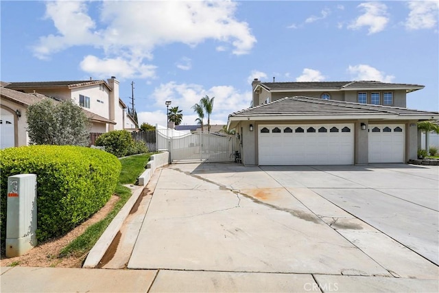 exterior space with a garage, fence, stucco siding, a gate, and concrete driveway