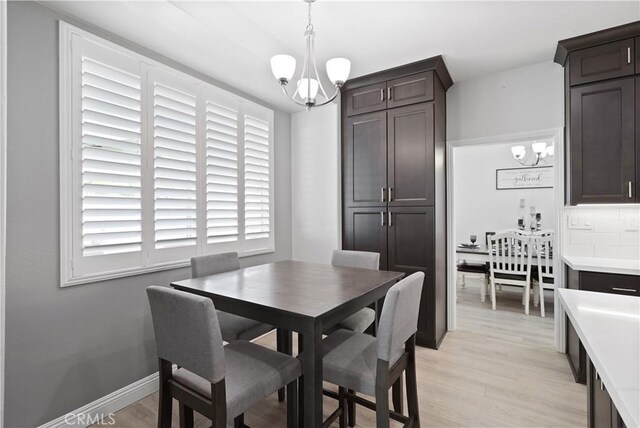 dining room featuring a notable chandelier and light wood-style flooring